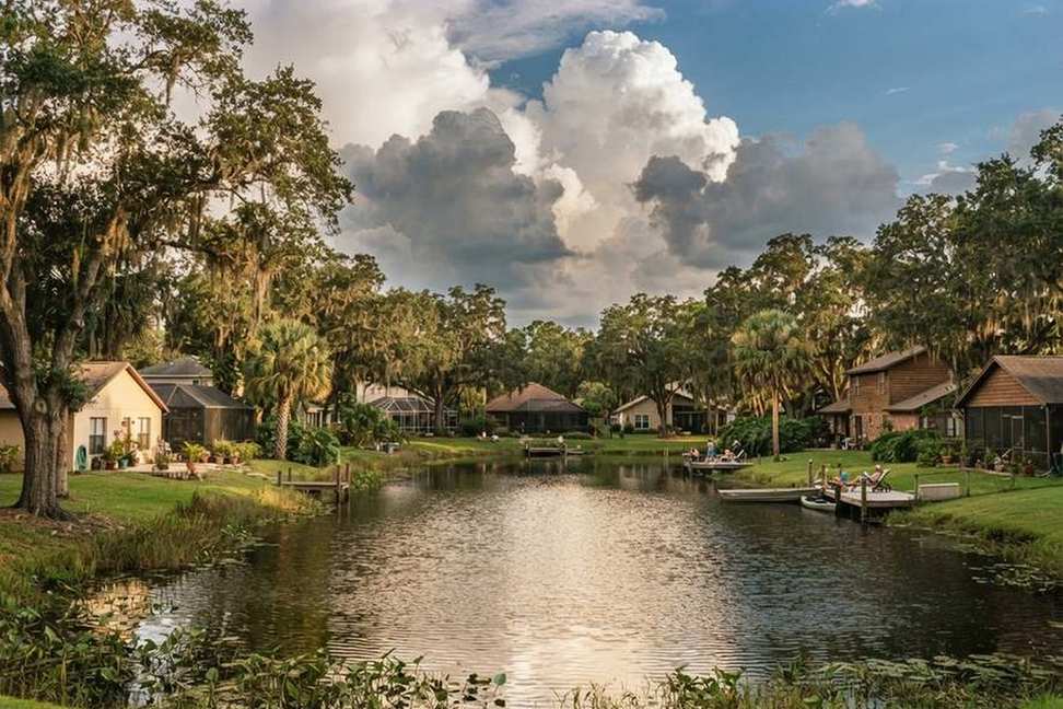 Homes and docks around a residential lake under building storm clouds